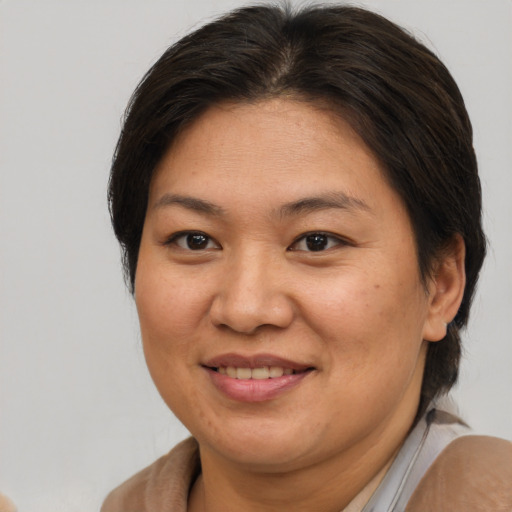 Joyful asian adult female with medium  brown hair and brown eyes