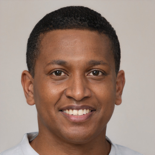 Joyful black young-adult male with short  brown hair and brown eyes