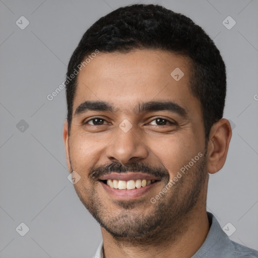 Joyful latino young-adult male with short  black hair and brown eyes