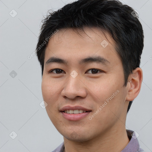 Joyful asian young-adult male with short  black hair and brown eyes