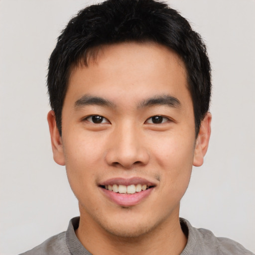 Joyful asian young-adult male with short  black hair and brown eyes