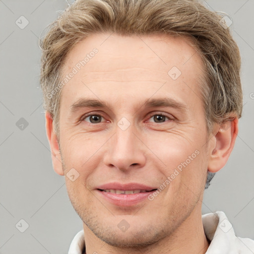 Joyful white adult male with short  brown hair and grey eyes