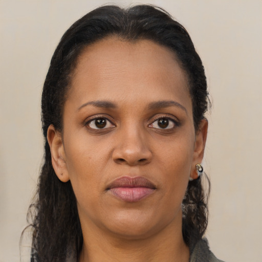 Joyful black young-adult female with long  brown hair and brown eyes
