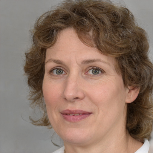 Joyful white adult female with medium  brown hair and blue eyes