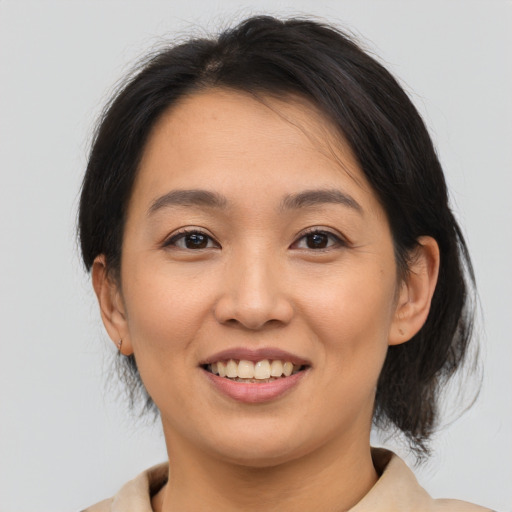 Joyful asian young-adult female with medium  brown hair and brown eyes