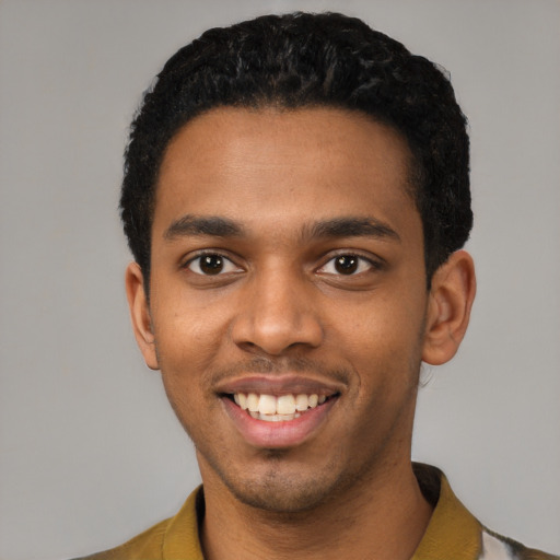 Joyful black young-adult male with short  black hair and brown eyes