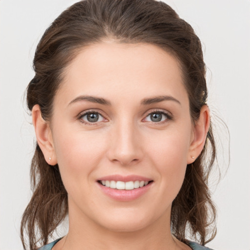 Joyful white young-adult female with medium  brown hair and grey eyes