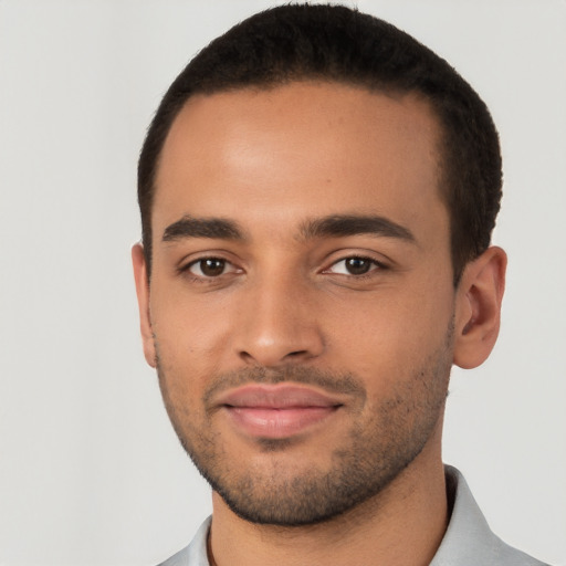 Joyful latino young-adult male with short  black hair and brown eyes