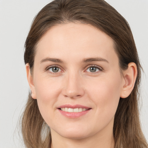 Joyful white young-adult female with long  brown hair and grey eyes