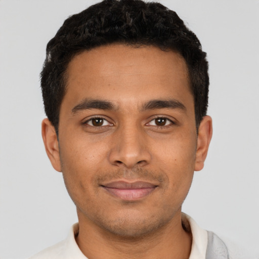 Joyful latino young-adult male with short  black hair and brown eyes