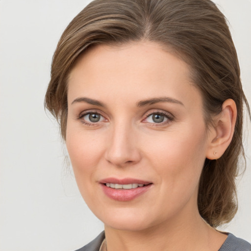 Joyful white young-adult female with medium  brown hair and grey eyes