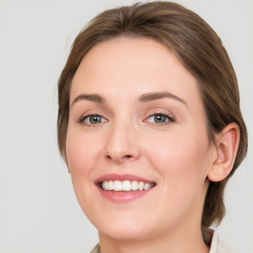 Joyful white young-adult female with medium  brown hair and grey eyes