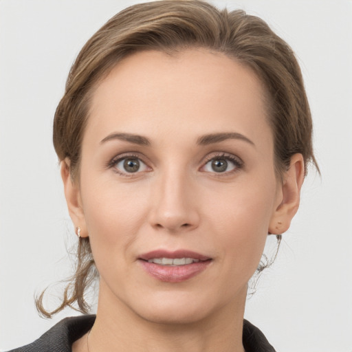 Joyful white young-adult female with medium  brown hair and grey eyes