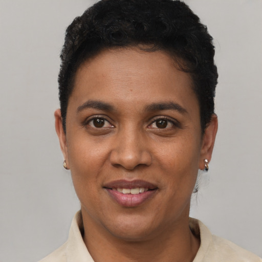 Joyful black young-adult female with short  black hair and brown eyes