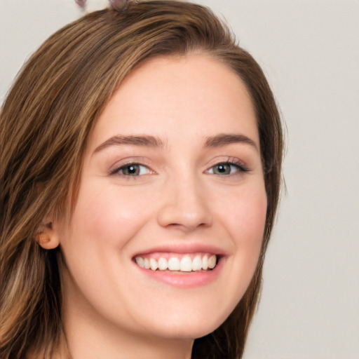 Joyful white young-adult female with long  brown hair and grey eyes