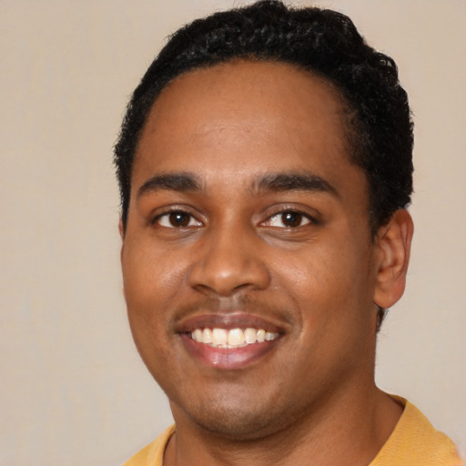 Joyful black young-adult male with short  black hair and brown eyes