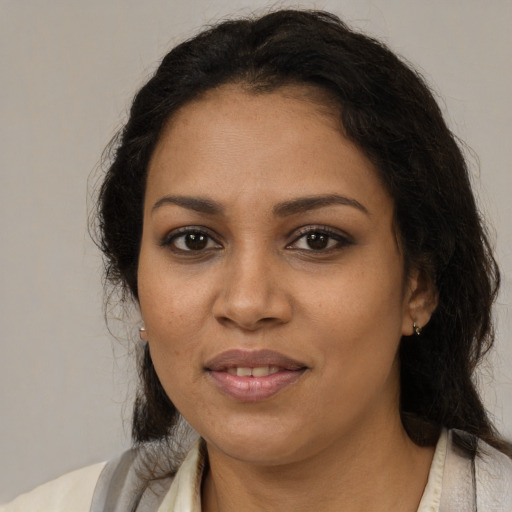 Joyful black adult female with long  brown hair and brown eyes