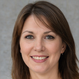 Joyful white adult female with medium  brown hair and grey eyes