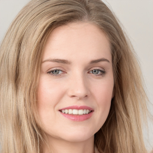 Joyful white young-adult female with long  brown hair and grey eyes