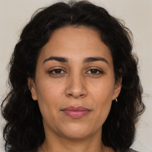 Joyful latino adult female with long  brown hair and brown eyes