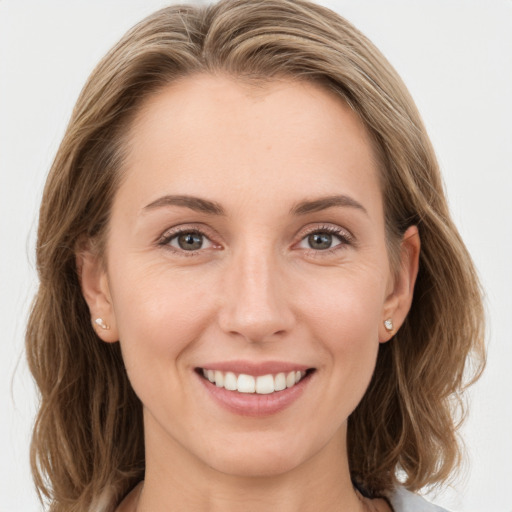 Joyful white young-adult female with medium  brown hair and grey eyes