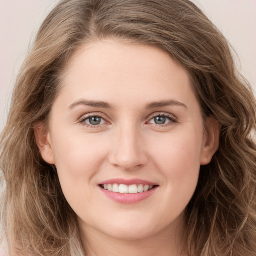 Joyful white young-adult female with long  brown hair and green eyes