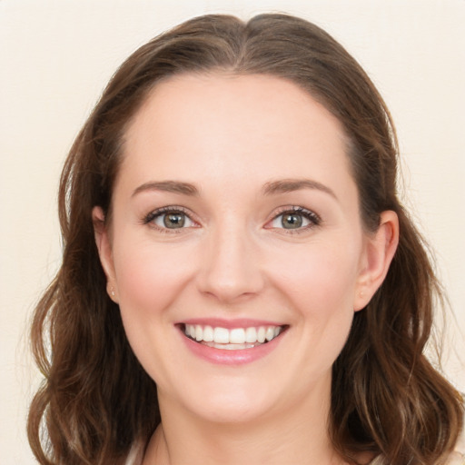 Joyful white young-adult female with long  brown hair and green eyes