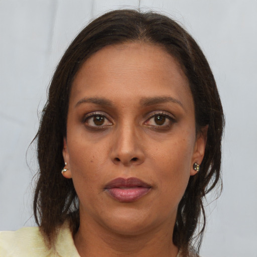Joyful black young-adult female with long  brown hair and brown eyes