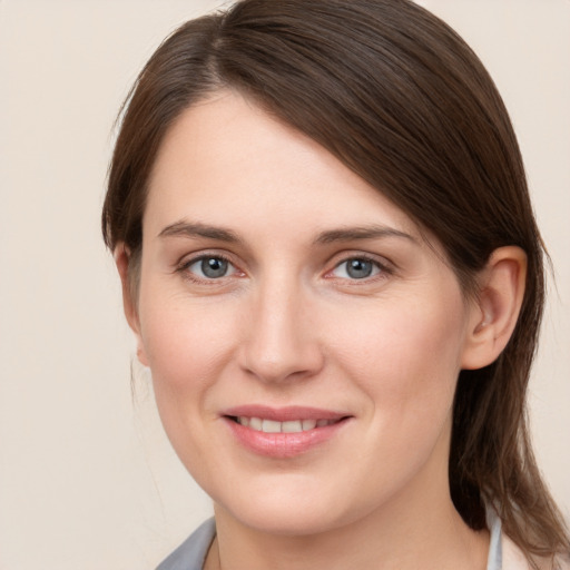 Joyful white young-adult female with medium  brown hair and grey eyes