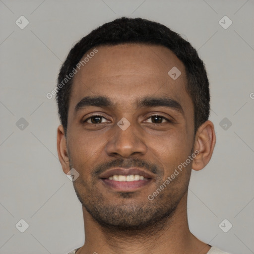 Joyful black young-adult male with short  black hair and brown eyes