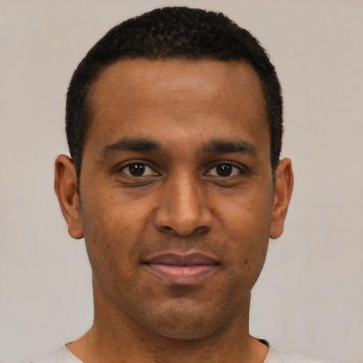 Joyful black young-adult male with short  black hair and brown eyes