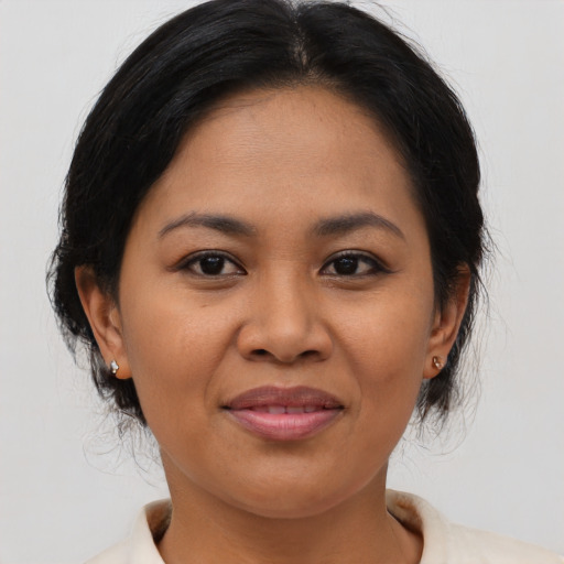 Joyful asian adult female with medium  brown hair and brown eyes