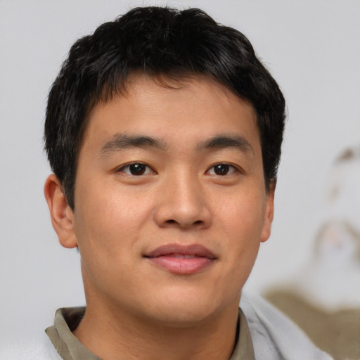 Joyful asian young-adult male with short  brown hair and brown eyes