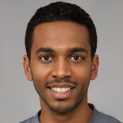 Joyful black young-adult male with short  black hair and brown eyes