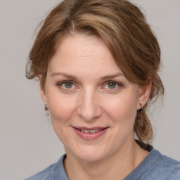 Joyful white adult female with medium  brown hair and blue eyes