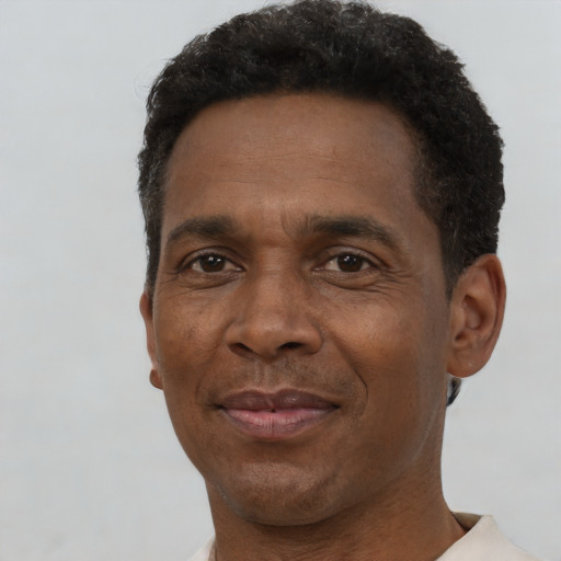 Joyful black adult male with short  brown hair and brown eyes