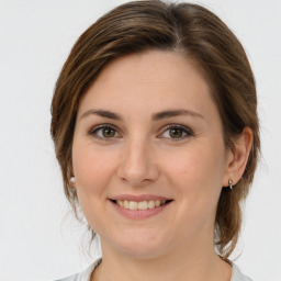 Joyful white young-adult female with medium  brown hair and green eyes