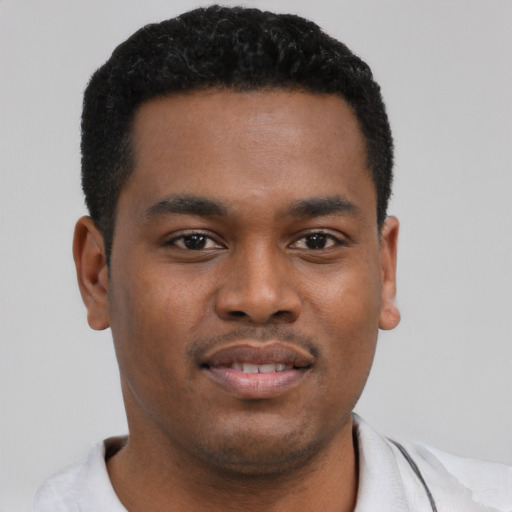 Joyful black young-adult male with short  black hair and brown eyes