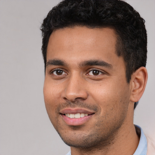Joyful white young-adult male with short  black hair and brown eyes