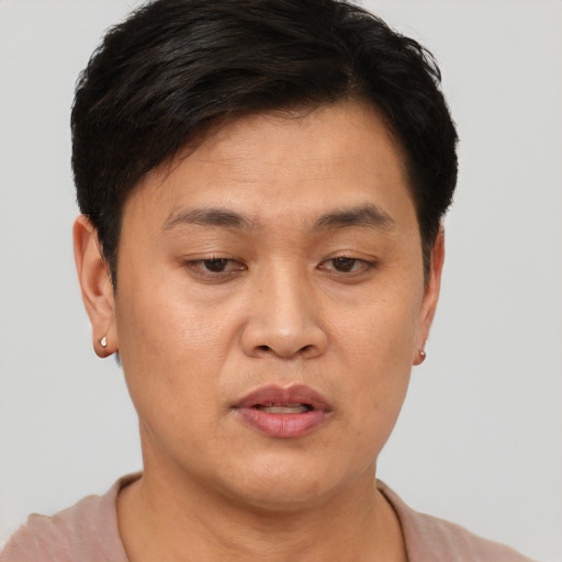 Joyful asian adult male with short  brown hair and brown eyes