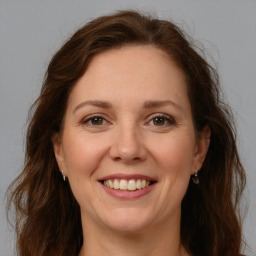 Joyful white adult female with long  brown hair and brown eyes