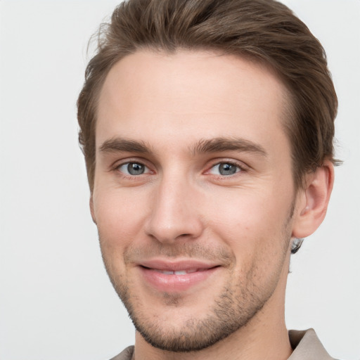 Joyful white young-adult male with short  brown hair and grey eyes