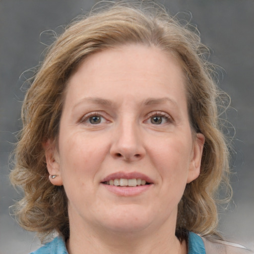 Joyful white adult female with medium  brown hair and blue eyes