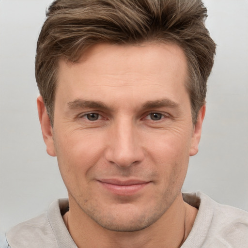 Joyful white adult male with short  brown hair and grey eyes