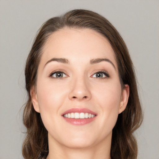 Joyful white young-adult female with long  brown hair and grey eyes