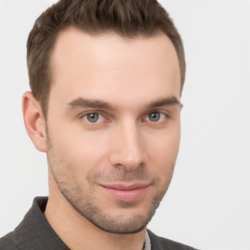 Joyful white young-adult male with short  brown hair and grey eyes