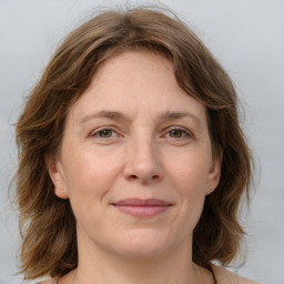 Joyful white adult female with medium  brown hair and grey eyes