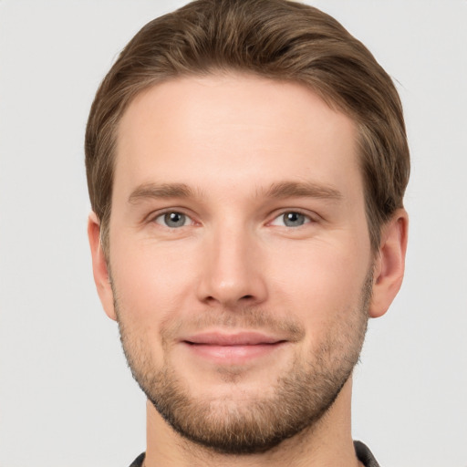 Joyful white young-adult male with short  brown hair and grey eyes