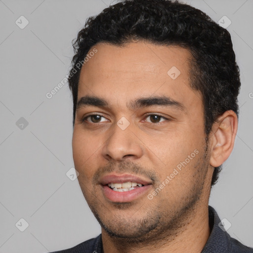 Joyful white young-adult male with short  black hair and brown eyes