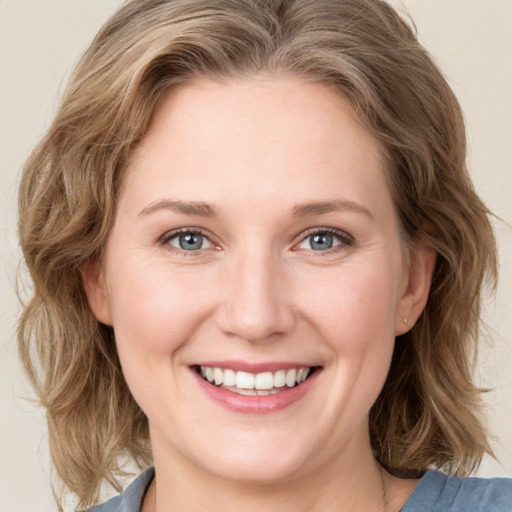 Joyful white young-adult female with medium  brown hair and blue eyes